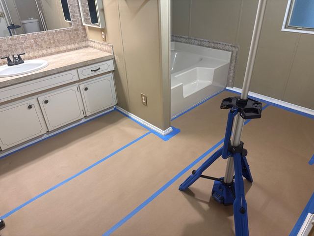 Bathroom vanity area opened to wet subfloor, and the protected floor with an air mover.