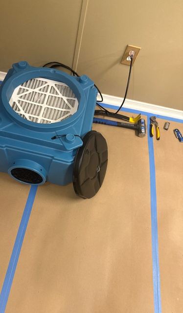 Rotted flooring torn open, and drying equipment running on a protected floor.